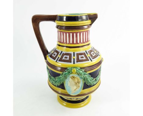 A Wedgwood majolica jug, circa 1870, cylindrical baluster form, relief moulded with classical portrait medallions and laurel 