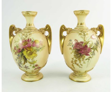 A pair of Royal Worcester blush ivory ground two handle vases, florally decorated to two sides in coloured enamels between gi