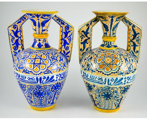 A Near Pair of Middle Eastern Glazed Ceramic two handled ewers, decorated in cobalt blue and ochre coloured enamels on a whit