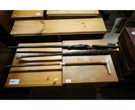 A white metal and horn handled walking stick and a carved ebony walking stick and one other 