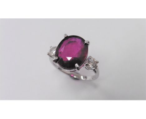 9ct ruby and diamond trilogy ring set in 18ct gold. Oval cut ruby ( fracture filled )weighing approx 9ct with a 0.30ct brilia
