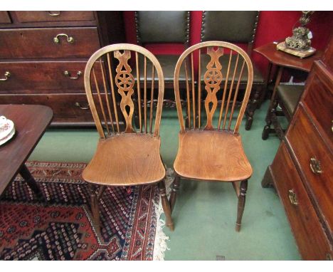 A set of four elm seated wheel and stick back chairs