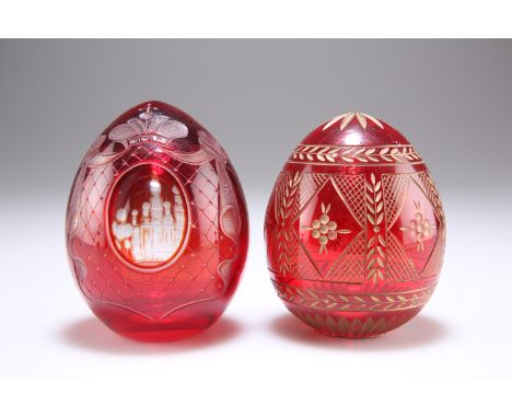 A 20th CENTURY RUSSIAN FABERGE RUBY GLASS EGG engraved with ST PETERSBURG, with Faberge label to base, 11cm high,and another 
