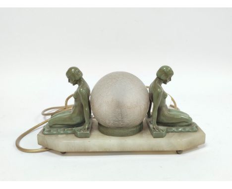 Art Deco verdigris bronze table lamp modelled as opposing seated nude females with glass shade to the centre, raised on alaba