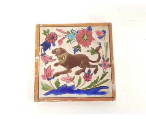Antique Persian pottery tile decorated with polychrome subject of a lion amongst foliage &amp; flowers, 15cm x 15cm. 