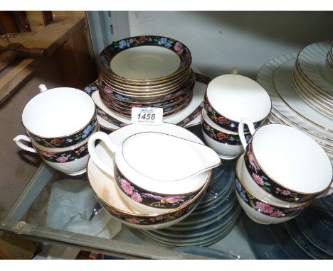 A Teaset including six cups and saucers, cake plate, tea plates, milk jug and sugar bowl, white with black border and flowers