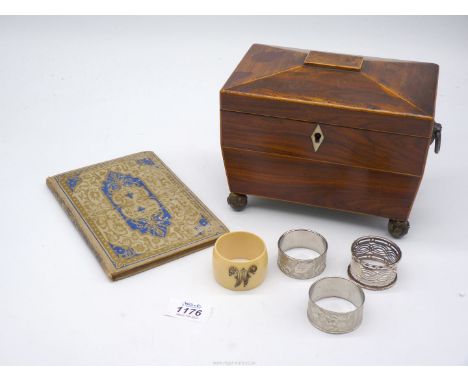 A two compartment tea caddy on metal feet with both interior lids and four napkin rings including Bakelite and epns.