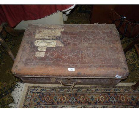 A large leather covered travel trunk with stitched decoration and luggage labels having fabric lining, metal handle and lock,