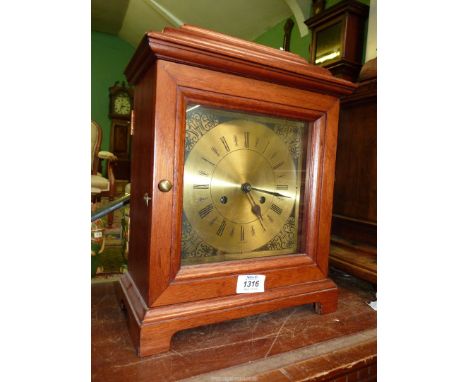 A wooden Mantle clock with brass effect face, with key and pendulum, 11" wide x 6" deep x 15" tall.