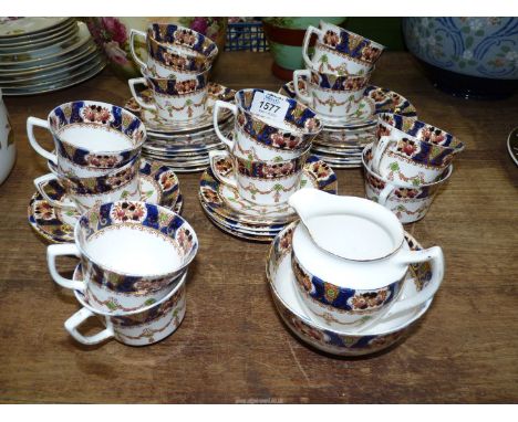 A part Teaset in white with dark blue border, with swags and floral decoration and including twelve each cups, saucers and te