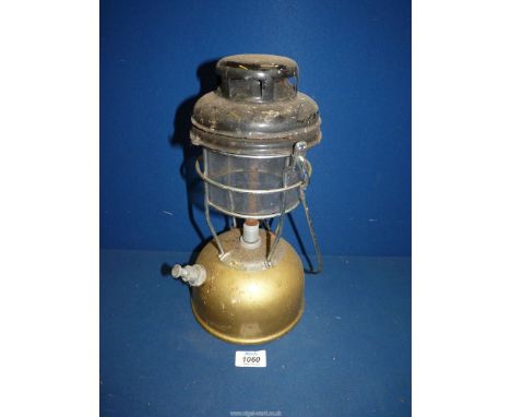 A vintage gold coloured Tilley lamp.