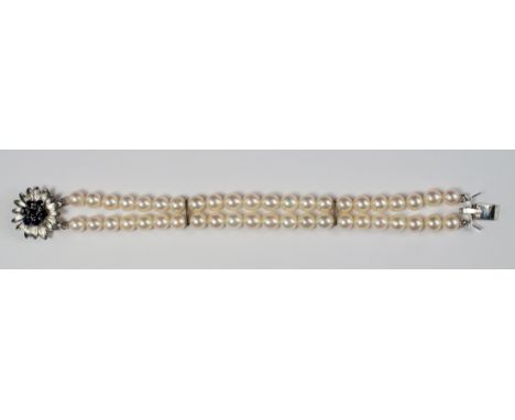A cultured pearl double row bracelet, with 14ct white gold and sapphire cluster flower head form clasp, approx 18cm. CONDITIO
