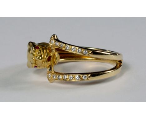 An 18ct gold and diamond set panther ring, Carrera y Carrera, the panther with ruby set eyes, grasping a diamond set stirrup 