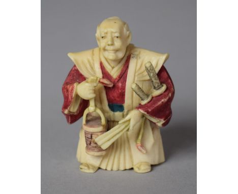 An Early 20th Century Japanese Carved Netsuke in the Form of a Robed Master with Bucket in Hand and Swords Decorated with Pol