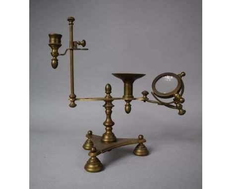 A Reproduction Georgian Style Brass Desk Top Reading Lamp with Adjustable Candle Holder, Hinged Magnifying Glass and Tripod S