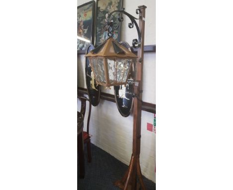 An oak framed with cast iron scroll lantern standard lamp.