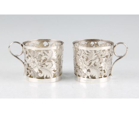 A pair of late 19th/early 20th Century Chinese export silver glass lined tea cups, the pierced body of floral, foliage and sc