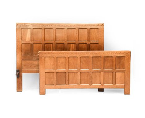 Workshop of Robert Mouseman Thompson (Kilburn): An English Oak 4'6" Panelled Bedstead, the headboard and footboard with penny