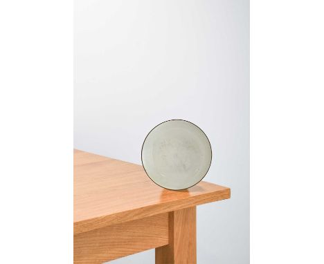 Lucie Rie (1902-1995): A Stoneware Side Plate, circa 1959, covered with an all over white glaze, manganese rim, impressed LR 