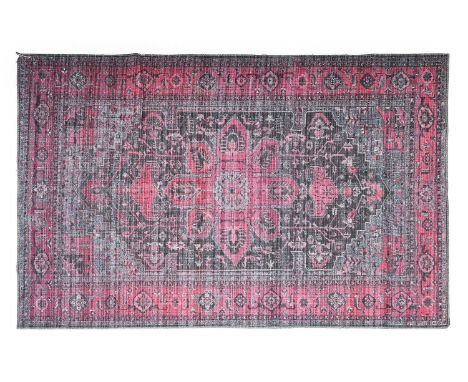 A Contemporary Machine Made Carpet of Oriental Design, the charcoal field with a central candy pink medallion framed by spand