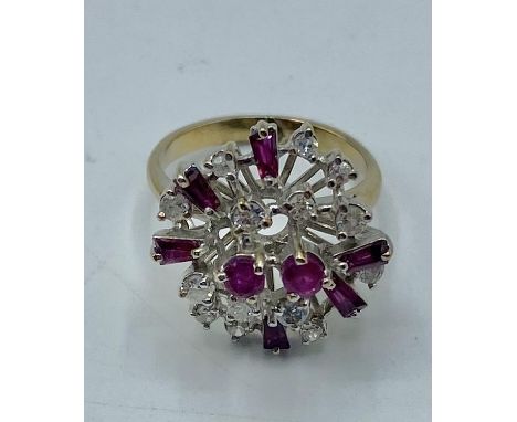 An unmarked yellow and white metal ruby and diamond cluster ring. 5.75g. Size L. 