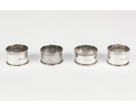 FOUR EARLY TWENTIETH CENTURY SILVER NAPKIN RINGS, including a plain pair, and an engine turned example, 2oz, (4)