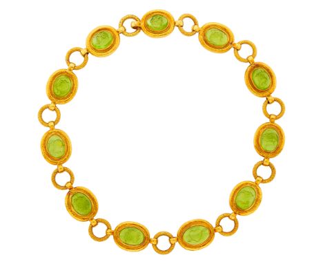 18 kt., 11 oval cabochon peridot intaglios of profile and heart and arrow motif, signed Gage, with English hallmarks, ap. 104