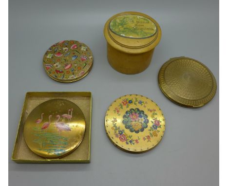 A Stratton compact decorated with flamingos, three other compacts and a powder buff in a treen pot 
