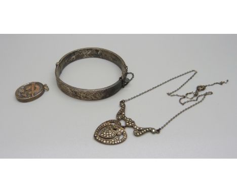 A Victorian silver locket with gold applied horseshoe, a silver bangle and a silver and marcasite necklace, (necklace require