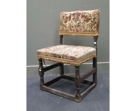 An 18th century oak chair with early tapestry upholstered back and seat, on turned supports (tapestry worn)