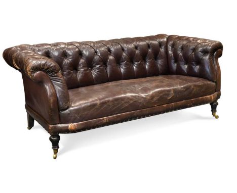 with low scroll back, upholstered in button back tan leather, on turned legs with casters,85 x 200 x 85cmProvenance:A Northam