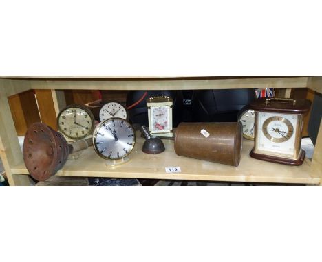 A shelf on mantel clocks and copper ware.