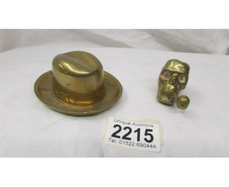 A brass stetson matchstriker marked Battersby hats and a skull matchstriker (go to bed light).