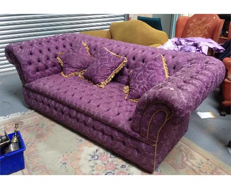 A large Chesterfield sofa upholstered in a purple fabric with matching cushions on bun feet 240cm wide 