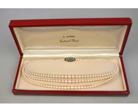 A three-row graduated cultured pearl necklace on paste set snap, in fitted case