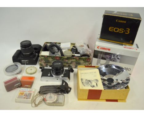 A quantity of modern camera equipment, including Canon EOS 20D digital SLR, EOS-3, 35 mm SLR and Nikon Nikkormat FT2 35 mm LS
