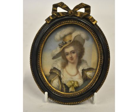 An oval portrait miniature on ivory of an early 18th century lady in feather bonnet and green dress, in parcel gilt frame Con