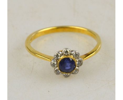 A circular cluster ring set with sapphire and diamonds in a white and yellow gold milgrain setting, size R