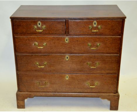 An 18th century oak chest of two short over three long graduated drawers having brass pulls and escutcheons raised on shaped 