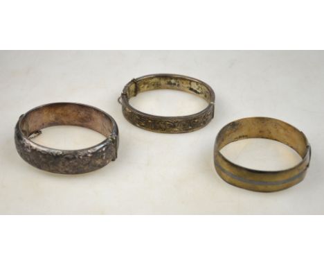 Three silver bangles, two hinged and half-engraved, one engine turned strap style, approx 2oz Condition Report One showing de