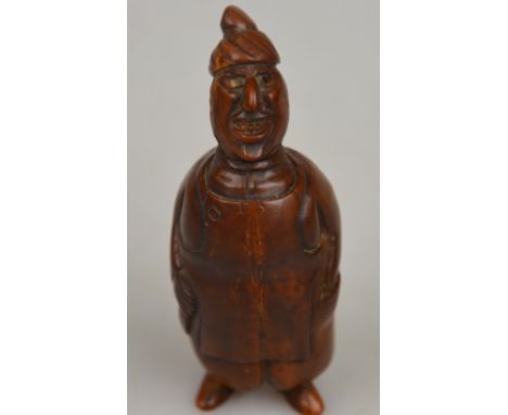 A Continental carved wood figural snuff box modelled as a portly inn-keeper, holding a bottle and wearing an apron, hinged co