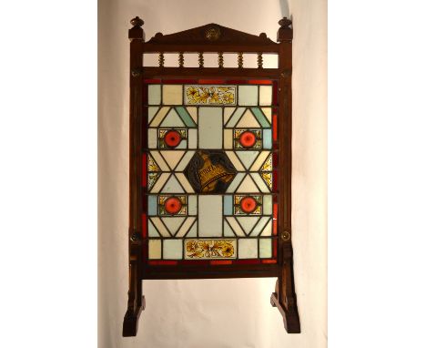 A late Victorian brass-mounted oak firescreen set with a leaded stained glass panel inscribed 'Curfew'