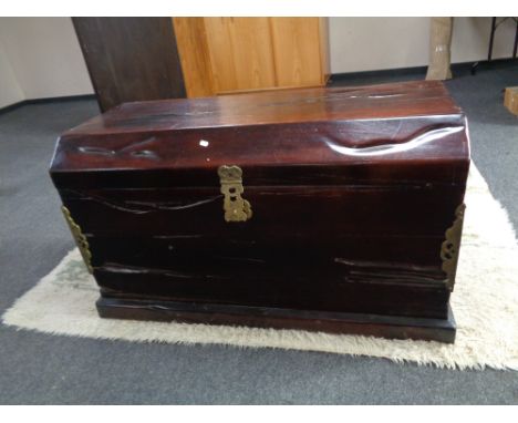 An eastern hardwood dome top trunk with brass mounts and handles, with padlock