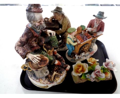A tray containing three Capodimonte figures, Tinker, Organ Grinder and Fruit Seller, together with a further Capodimonte flow
