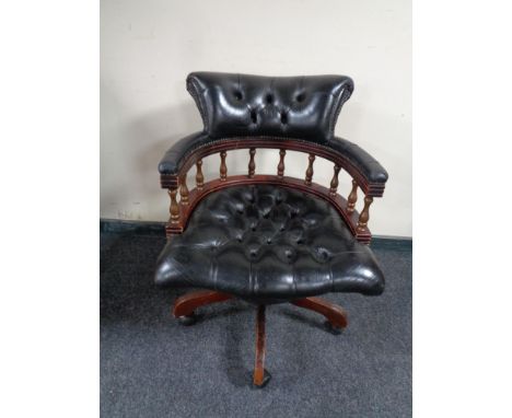 A black button leather swivel captain's desk chair 