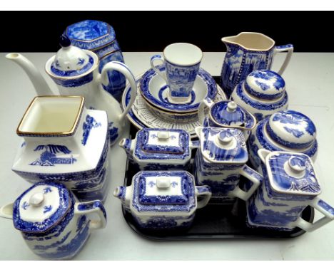 A tray containing a quantity of Ringtons china to include willow pattern teapots, caddies and jugs, cathedral tea caddy, cale