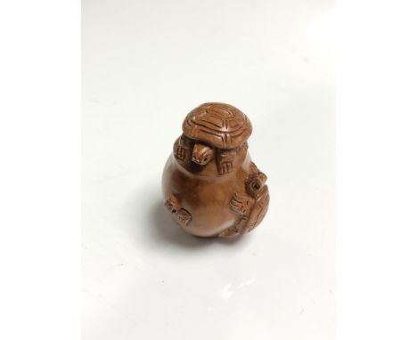 A carved Chinese hardwood netsuke - Turtles on a pot