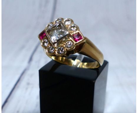 An 18 carat gold dress ring set 4 mm square princess cut diamond, surrounded by 8 further diamonds and 2 rubies