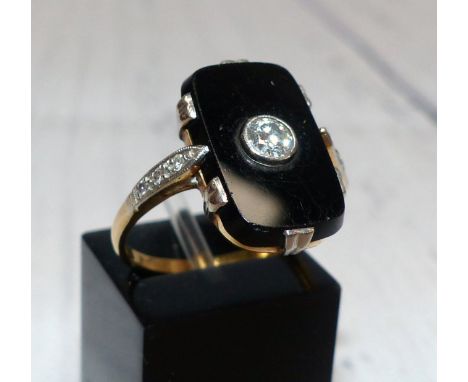 A mourning ring set with a diamond on rectangular black onyx base, with 3 diamonds to either shoulder, 3.9 gm, unmarked, test