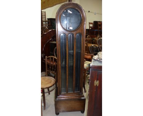 A 1930's oak longcase clock with glazed door and triple weight driven movement